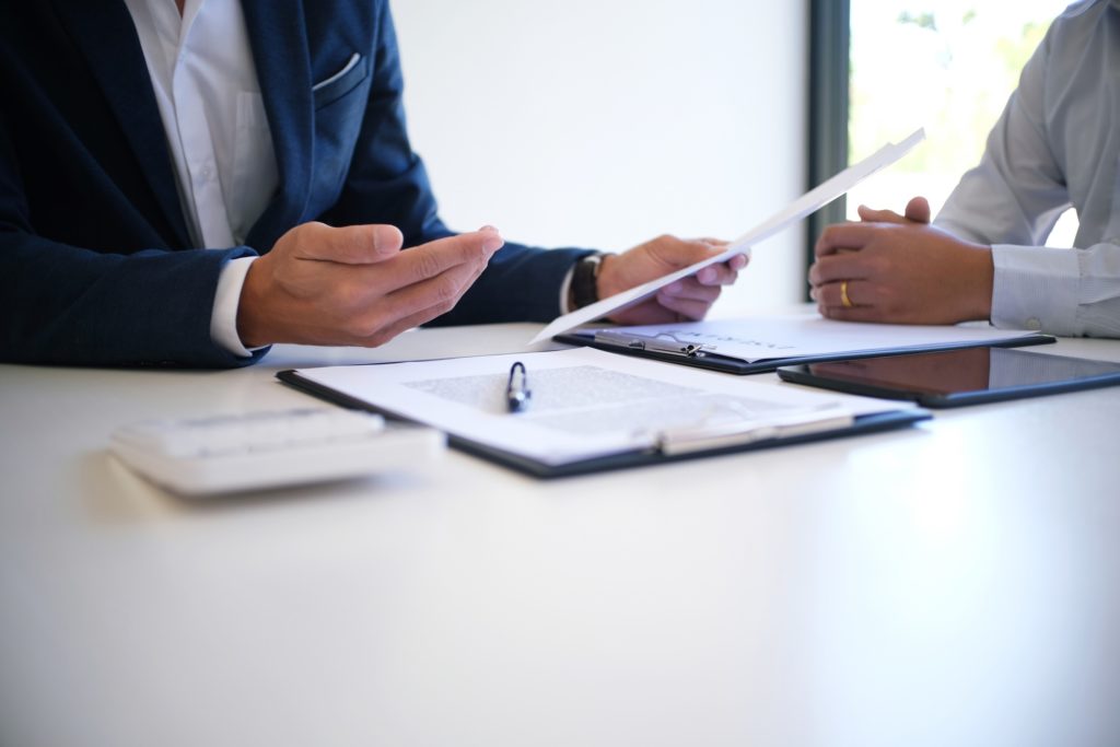Two people meeting over paperwork
